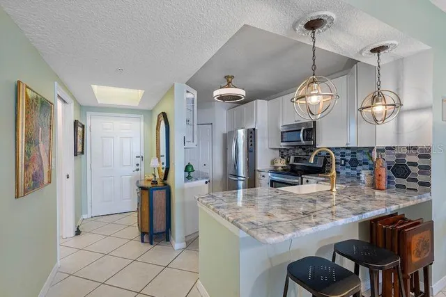 a kitchen with stainless steel appliances granite countertop a sink and a refrigerator