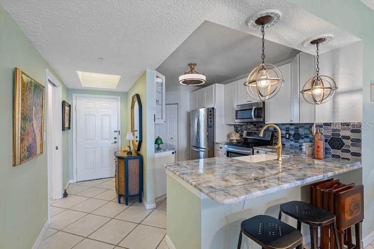 16550 Gulf Boulevard, Unit 545 North Redington Beach, FL 33708 - Photo 7 of 64 a kitchen with stainless steel appliances granite countertop a sink and a refrigerator