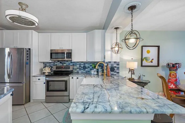 a kitchen with stainless steel appliances granite countertop a sink a stove microwave and cabinets