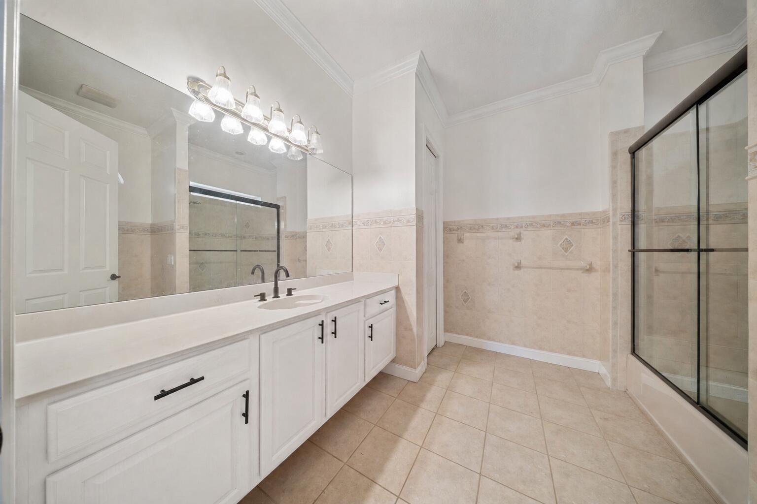 8686 Andrews Avenue Fort Pierce, FL 34945 - Photo 32 of 76 a spacious bathroom with a double vanity sink a large mirror and shower