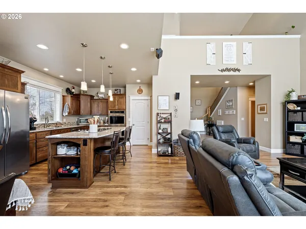 a living room with stainless steel appliances kitchen island granite countertop furniture and a view of kitchen