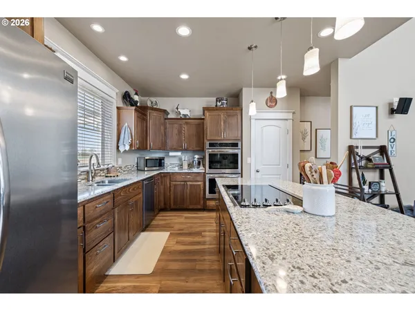 a kitchen with stainless steel appliances granite countertop a sink stove and refrigerator