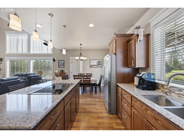 a kitchen with stainless steel appliances granite countertop a sink a stove and a refrigerator