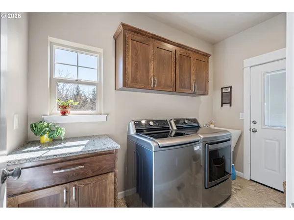 a kitchen with stainless steel appliances granite countertop wooden floor a stove a sink and a window