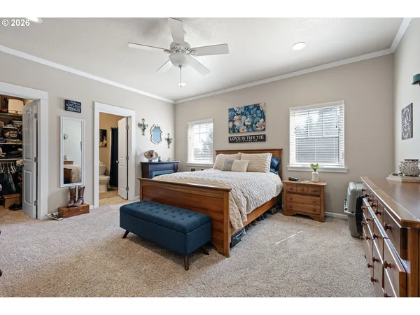 a spacious bedroom with a bed a couch and a chandelier