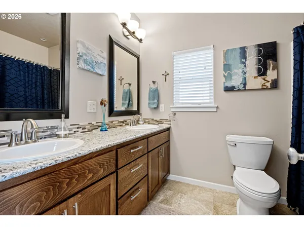 a bathroom with a granite countertop toilet sink and a mirror