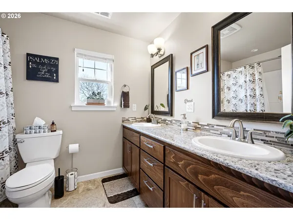 a bathroom with a granite countertop toilet sink and mirror