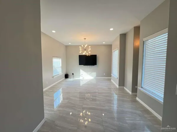a view of a hallway to a room with a flat screen tv