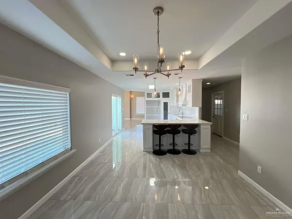 a view of a dining room with furniture a chandelier and wooden floor