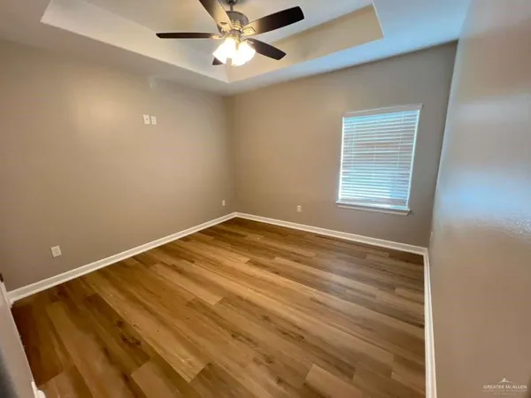 an empty room with a window and a ceiling fan