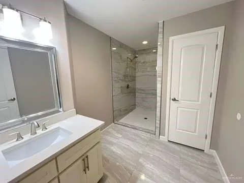 a bathroom with a shower sink and mirror