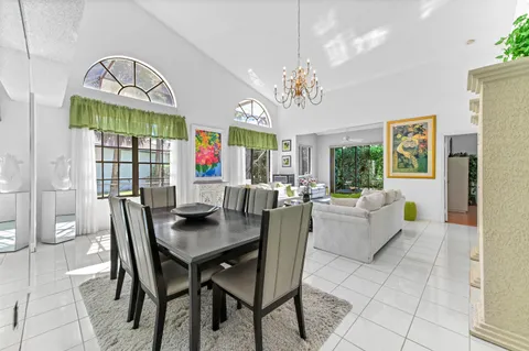 a view of a dining room with furniture a chandelier and a window