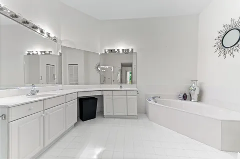 a spacious bathroom with a granite countertop sink a toilet a mirror and bathtub