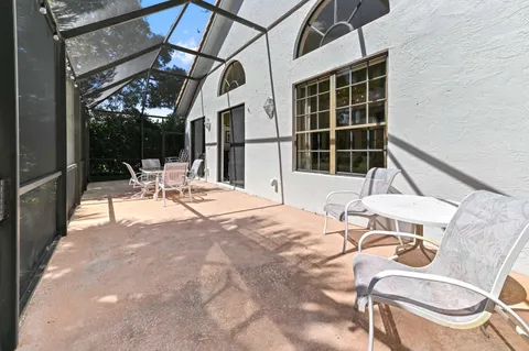a view of a patio with a table and chairs and potted plants