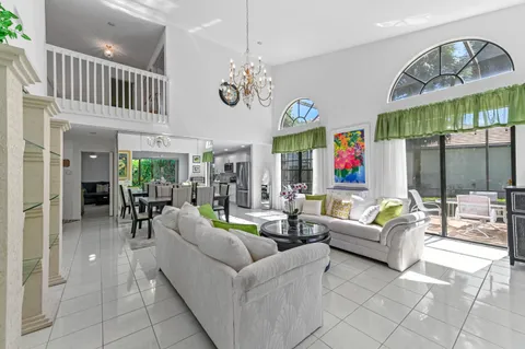 a living room with furniture a chandelier and a large window