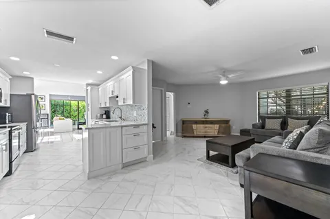 a living room with furniture a large window and kitchen view