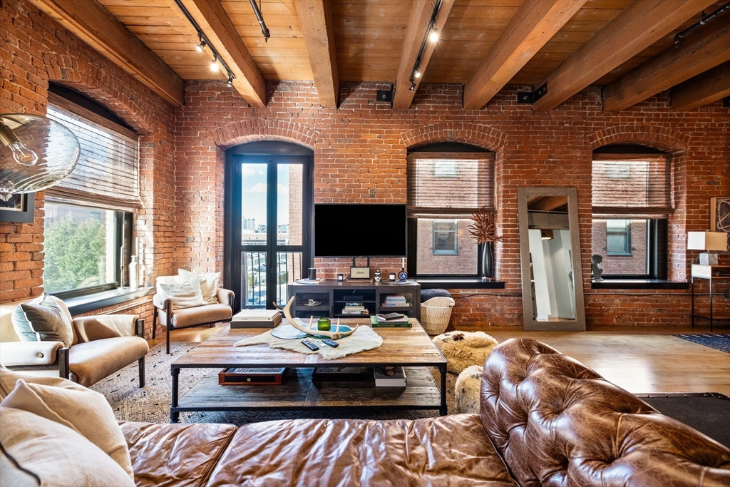 21 Wormwood Street, Unit 412 Boston, MA 02210 - Photo 2 of 11 a living room with a couch wooden floor and a large window