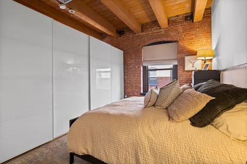a bedroom with a bed next to a window