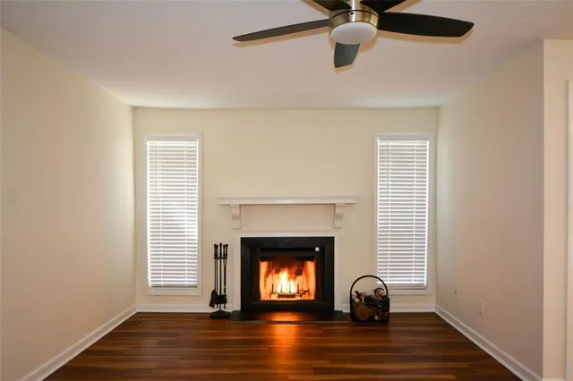 a view of empty room with wooden floor fan and window