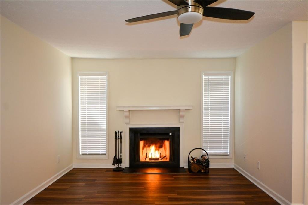 a view of empty room with wooden floor fan and window