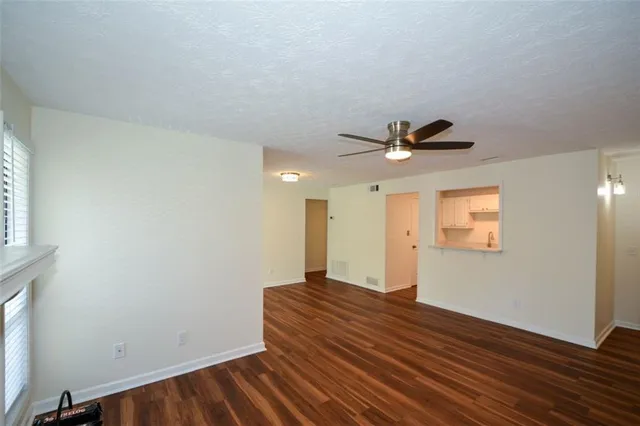 a view of a room with wooden floor and white walls