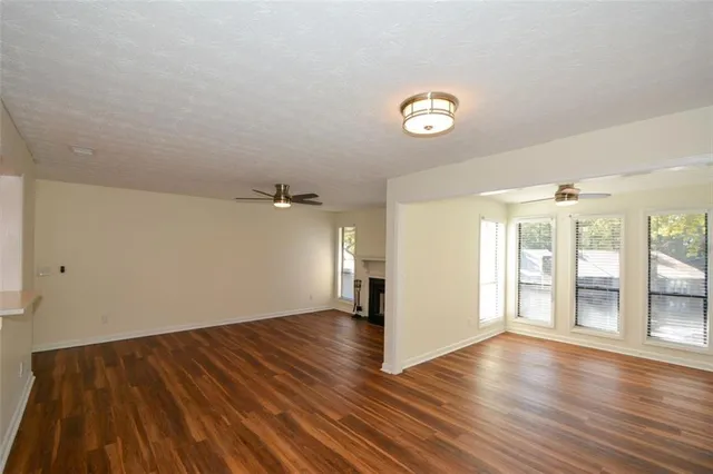 a view of a livingroom with wooden floor and a fireplace