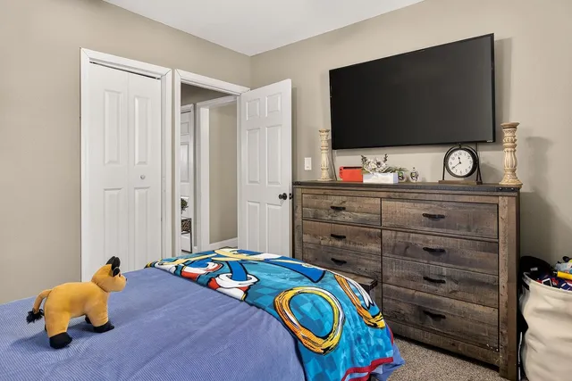 a bedroom with a bed and flat screen tv