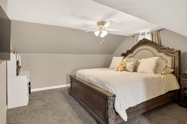 a bedroom with a bed and a ceiling fan
