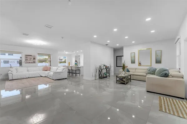 a living room with furniture and a view of kitchen