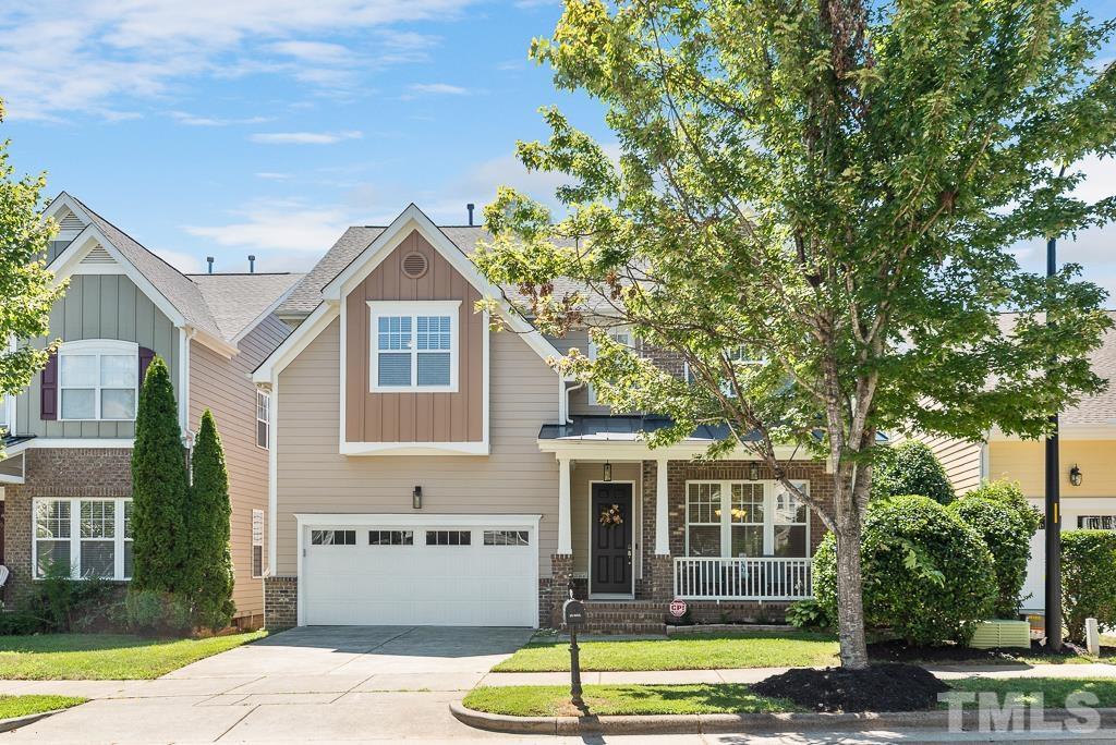 a front view of a house with a garden and trees