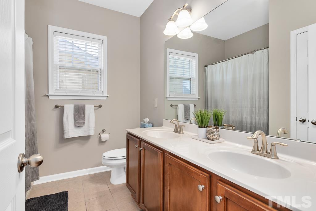 1136 Chapanoke Road Raleigh, NC 27603 - Photo 27 of 48 a bathroom with a sink a toilet and a mirror