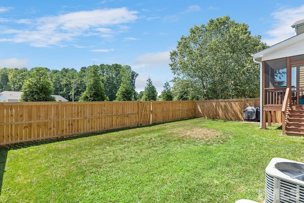 1136 Chapanoke Road Raleigh, NC 27603 - Photo 39 of 48 a backyard of a house with lots of green space and wooden fence