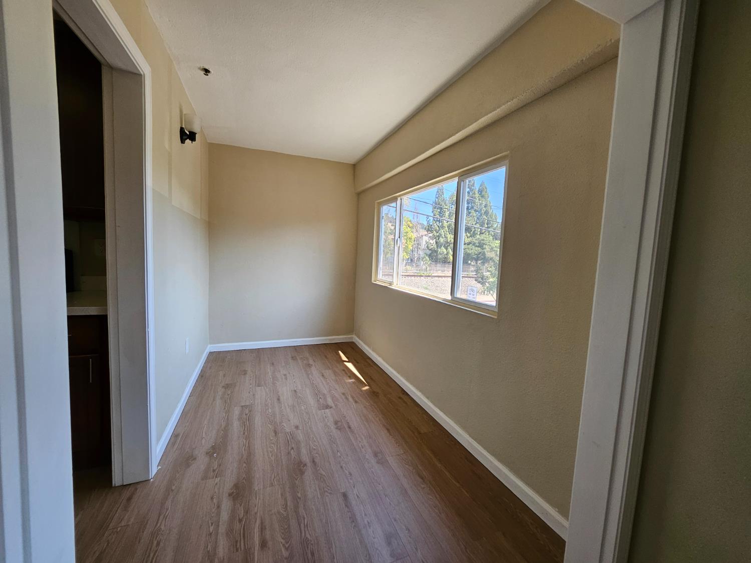 25231 Whitman Street, Unit 103 Hayward, CA 94544 - Photo 17 of 30 a view of an empty room with wooden floor and a window