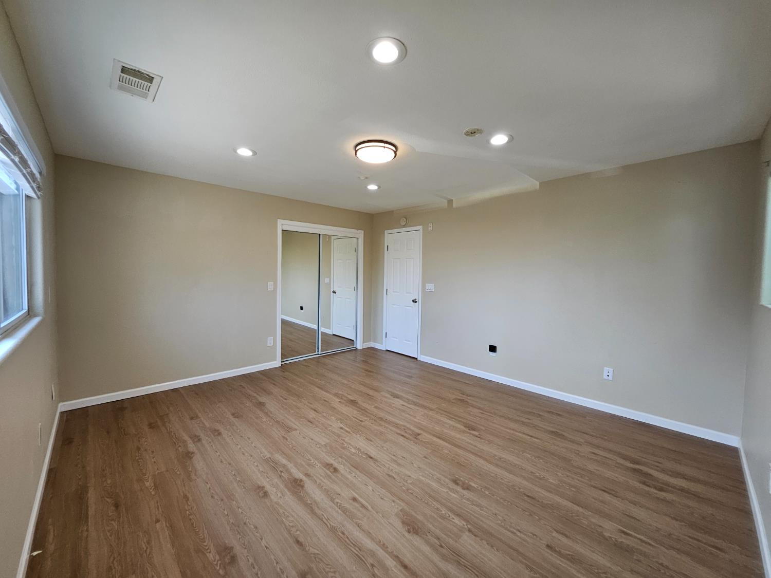 25231 Whitman Street, Unit 103 Hayward, CA 94544 - Photo 19 of 30 a view of an empty room with wooden floor and a window