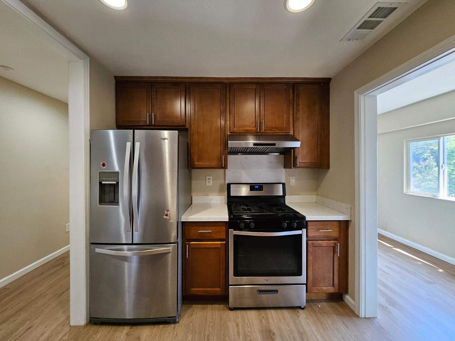 25231 Whitman Street, Unit 103 Hayward, CA 94544 - Photo 9 of 30 a kitchen with a refrigerator stove and wooden floor