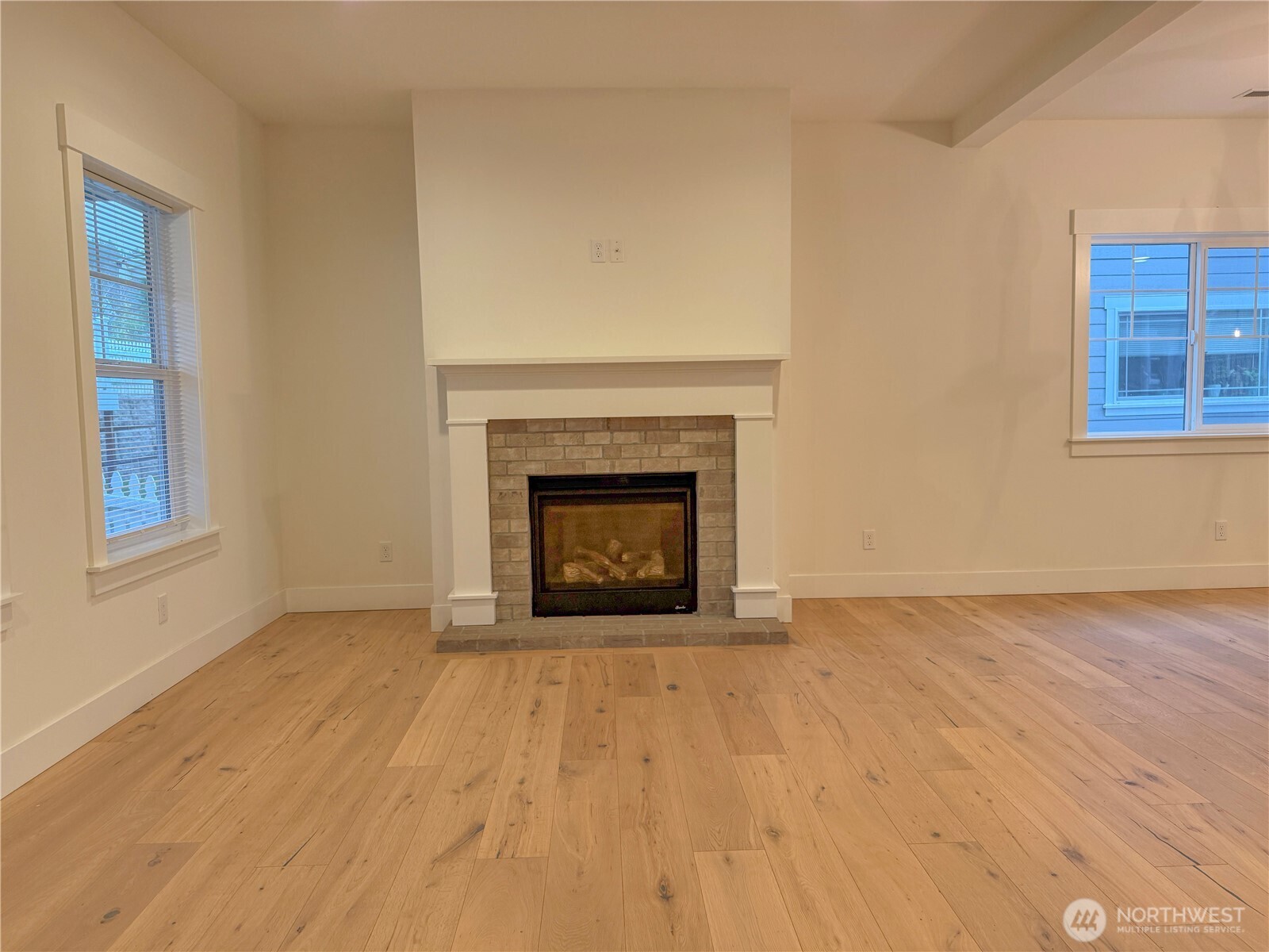 30 East Compass Lane, Unit A98524 Allyn, WA 98524 - Photo 5 of 36 a view of an empty room with wooden floor fireplace and a window