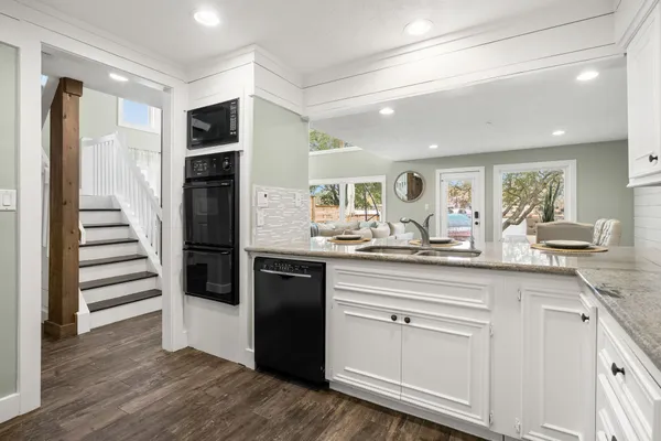a kitchen with white cabinets stainless steel appliances and sink