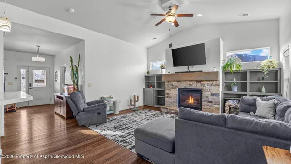 a living room with furniture a flat screen tv and a fireplace