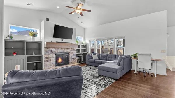 a living room with furniture a flat screen tv and a fireplace