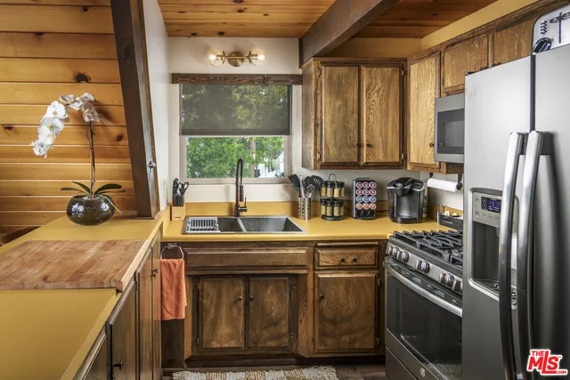 a kitchen with stainless steel appliances a stove a refrigerator and a sink