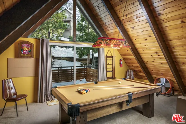 a bedroom with a bed and large windows