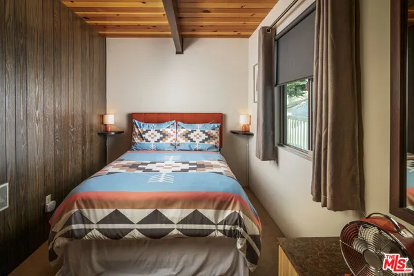 a view of a house with wooden fence and large trees