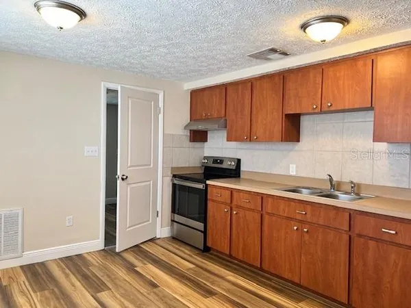 a kitchen with stainless steel appliances granite countertop a sink stove and cabinets
