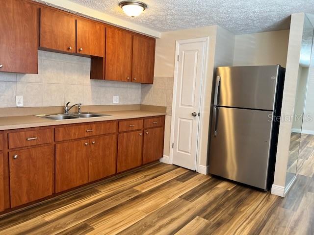 6413 Sutters Mill Road New Port Richey, FL 34653 - Photo 7 of 20 a kitchen with a sink a refrigerator and cabinets