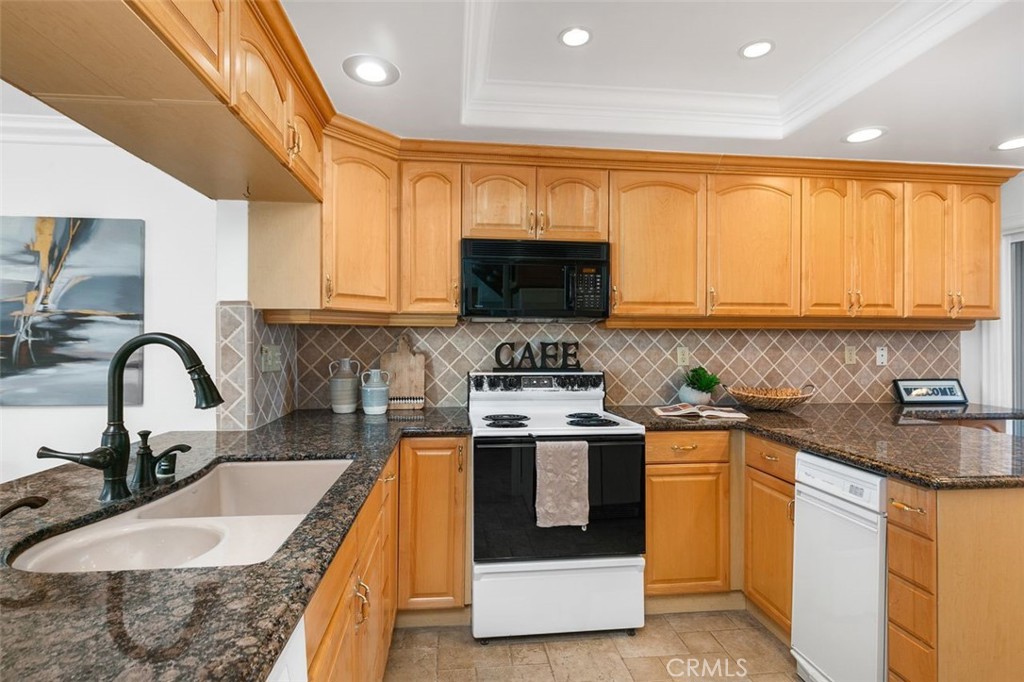 16117 St Croix Circle Huntington Beach, CA 92649 - Photo 19 of 45 a kitchen with stainless steel appliances granite countertop a stove a sink and a microwave