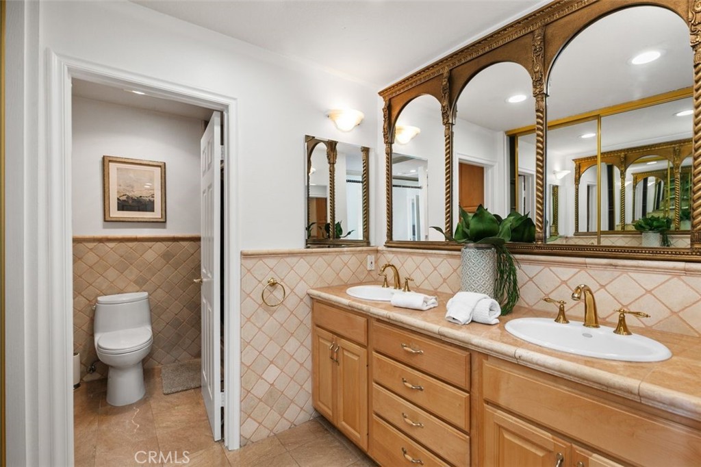 16117 St Croix Circle Huntington Beach, CA 92649 - Photo 25 of 45 a spacious bathroom with a granite countertop sink mirror and toilet