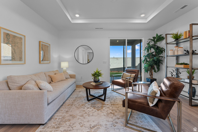 1589 South Fins Road, Unit 4178 Washington, UT 84780 - Photo 18 of 30 Spacious living area featuring a tray ceiling with recessed lighting, wood-finish flooring, and a large sliding glass door opening to a patio