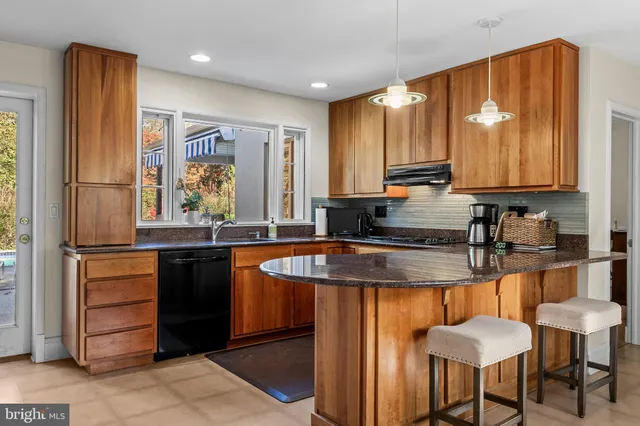 a kitchen with granite countertop a sink and a refrigerator