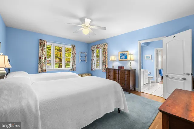 a bedroom with a large bed a flat tv screen and dresser