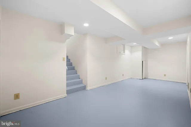 an empty room with wooden floor and white walls